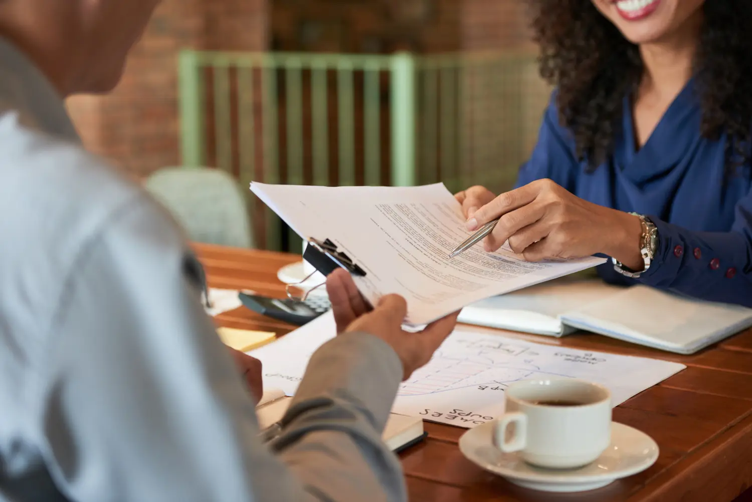 mulher entregando alguns contratos imobiliários