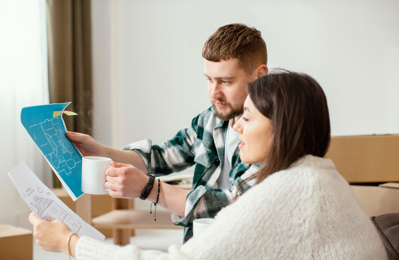 Casal analisando planta e buscando descobrir o que saber antes de comprar apartamento